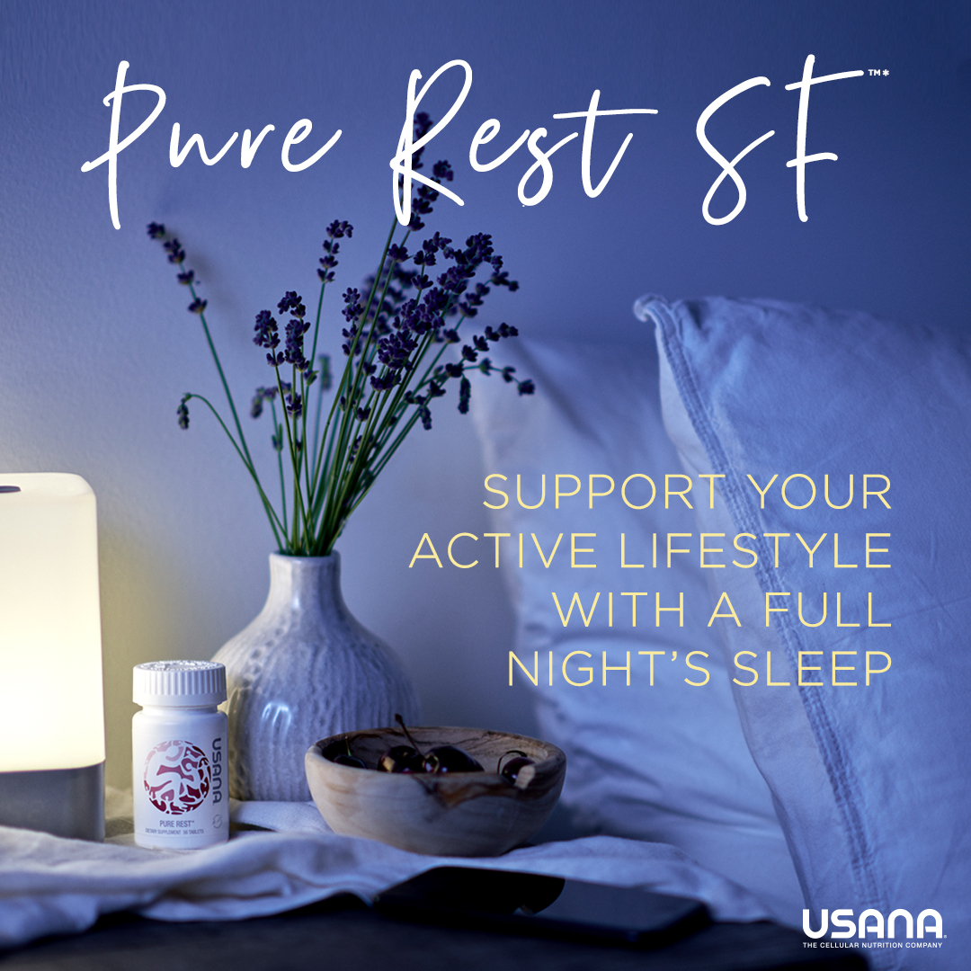 a vase, lamp and pure rest bottle ono the table beside the bed with 2 white pillows